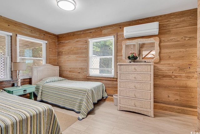 bedroom with wooden walls, light hardwood / wood-style floors, and an AC wall unit