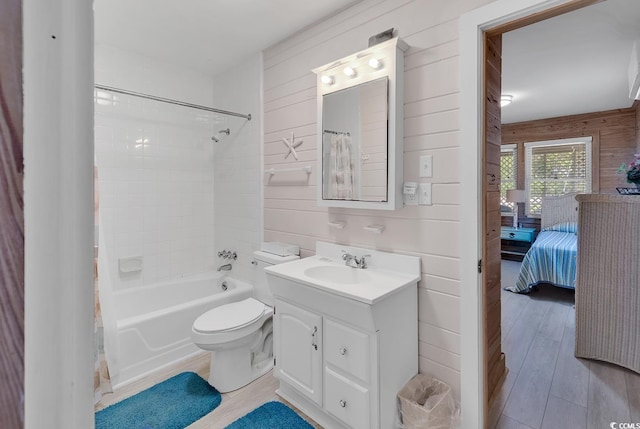 full bathroom featuring wood-type flooring, toilet, vanity, and wooden walls