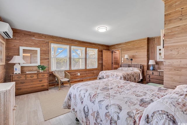 bedroom with light hardwood / wood-style flooring, wood walls, and a wall mounted AC