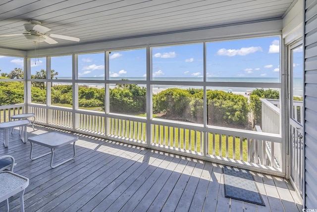 unfurnished sunroom featuring ceiling fan, wood ceiling, and a water view