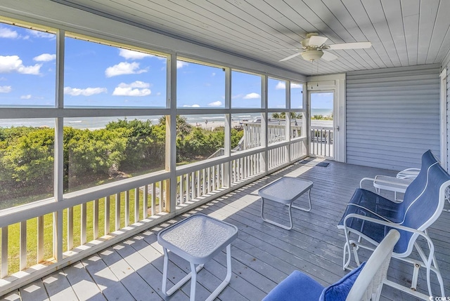 unfurnished sunroom featuring a water view, ceiling fan, and wooden ceiling