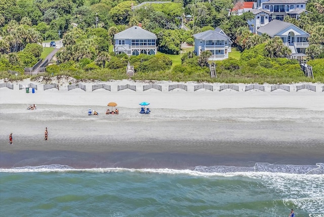 birds eye view of property with a water view and a beach view