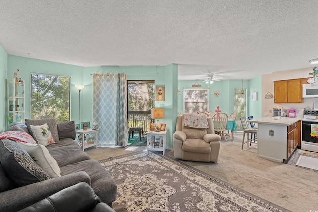 carpeted living room with a textured ceiling and ceiling fan