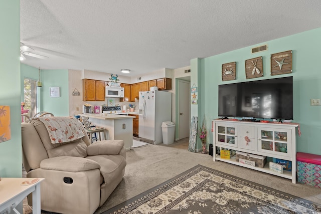 carpeted living room featuring ceiling fan and a textured ceiling