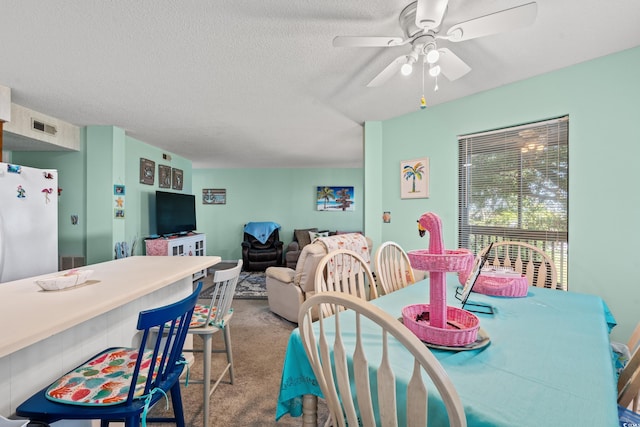 dining area with carpet flooring, ceiling fan, and a textured ceiling