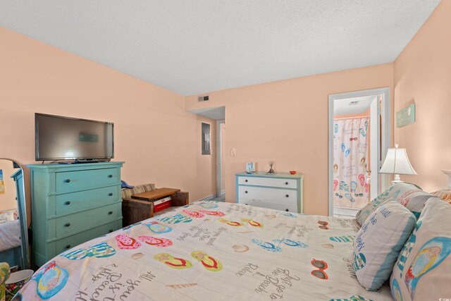 bedroom featuring a textured ceiling and ensuite bath