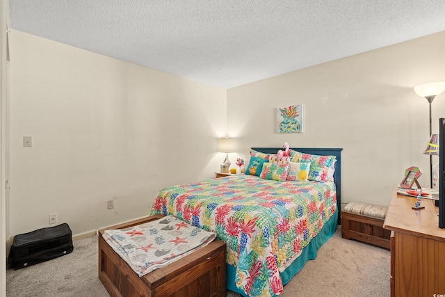 bedroom featuring light carpet and a textured ceiling