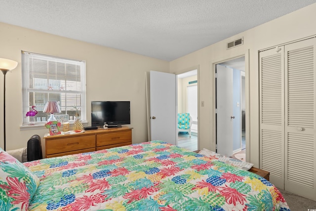 carpeted bedroom featuring a textured ceiling and a closet