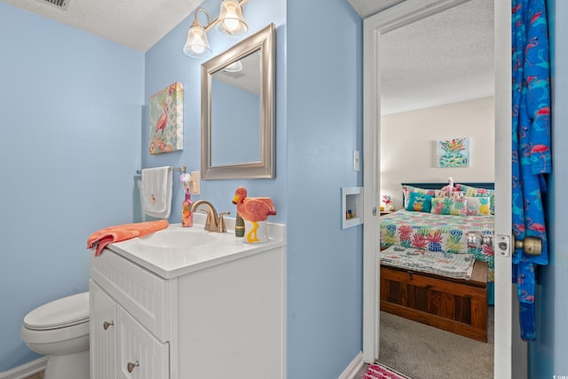 bathroom featuring vanity, toilet, and a textured ceiling