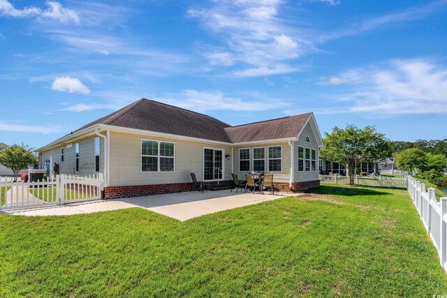 back of house with a patio area and a yard