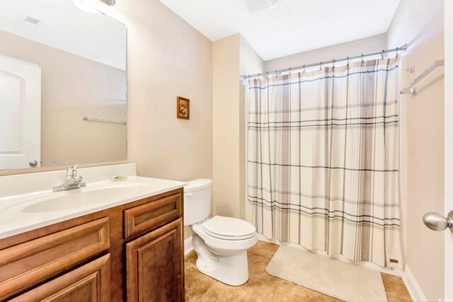 bathroom with oversized vanity, toilet, and tile floors