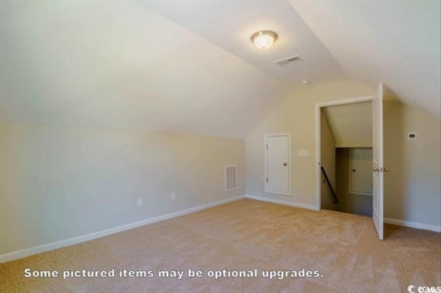 bonus room with lofted ceiling and light colored carpet