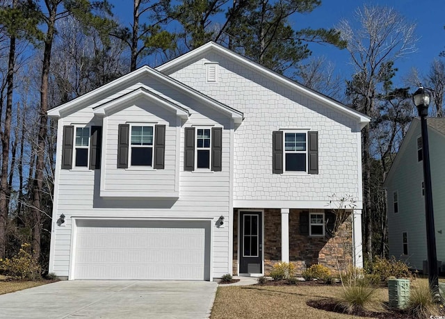 view of front of home featuring concrete driveway, an attached garage, and stone siding