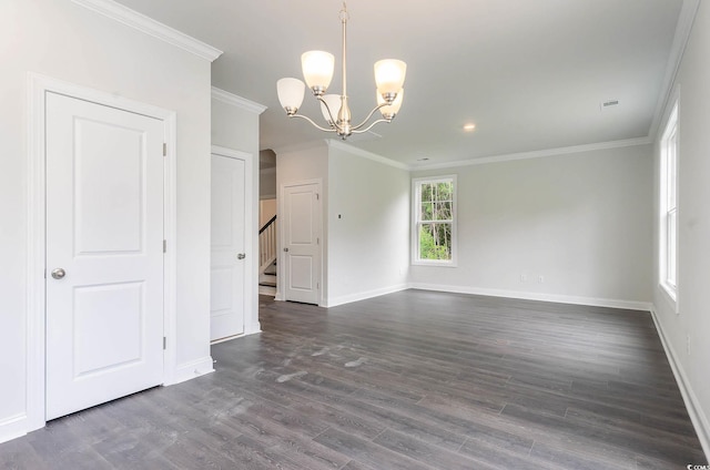 empty room with dark hardwood / wood-style flooring, ornamental molding, and a notable chandelier