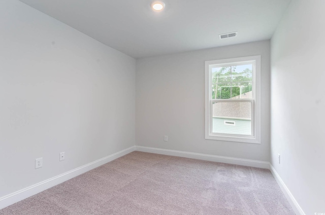 spare room featuring light colored carpet