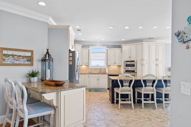 kitchen with appliances with stainless steel finishes, a kitchen breakfast bar, light stone counters, and decorative backsplash