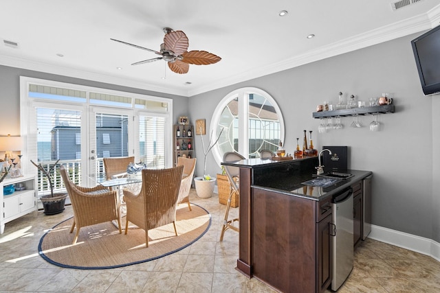 interior space featuring ceiling fan, sink, dark brown cabinetry, and ornamental molding