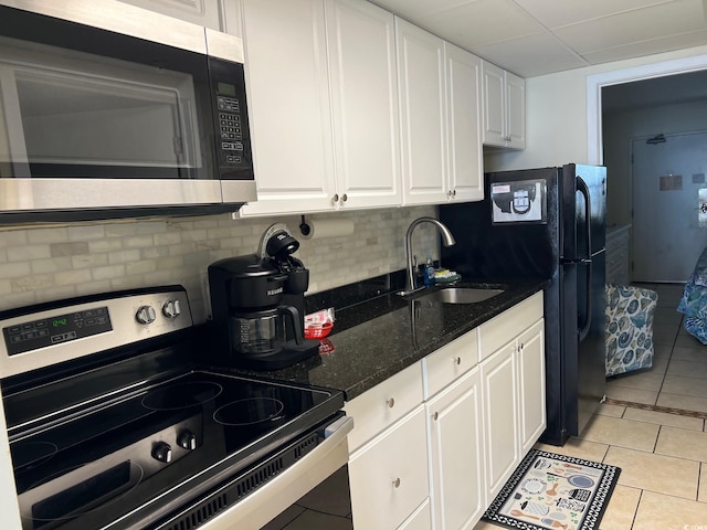 kitchen featuring white cabinetry, sink, stainless steel appliances, backsplash, and light tile patterned flooring