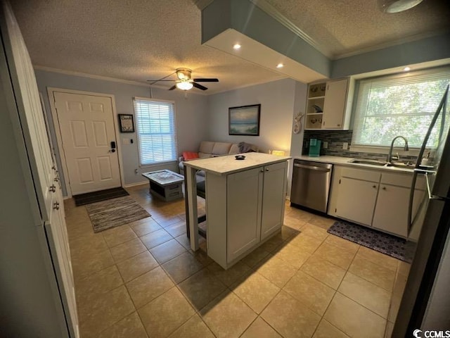 kitchen with ceiling fan, sink, a kitchen island, stainless steel dishwasher, and a textured ceiling