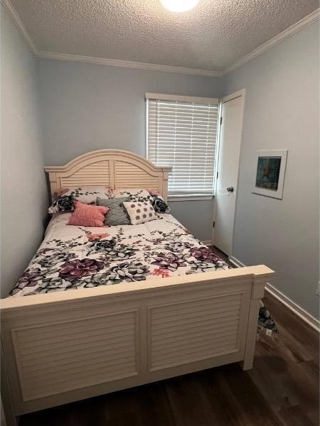 bedroom with ornamental molding, a textured ceiling, and dark hardwood / wood-style floors