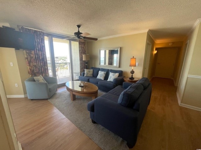 living room featuring a textured ceiling, crown molding, a wall of windows, hardwood / wood-style flooring, and ceiling fan