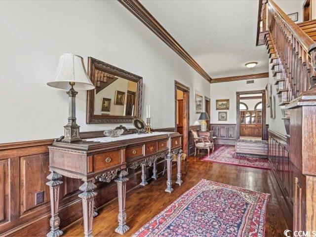 foyer with a textured ceiling, crown molding, and dark hardwood / wood-style flooring