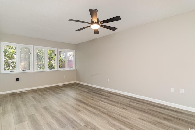 spare room with a textured ceiling, light wood-type flooring, and ceiling fan