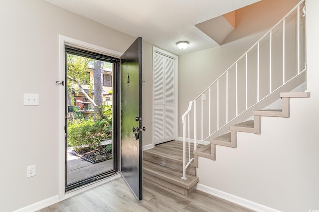 entrance foyer featuring light hardwood / wood-style floors and a textured ceiling