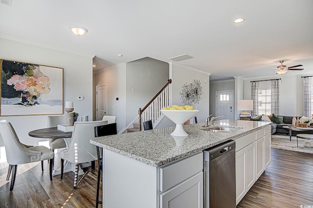 kitchen with white cabinetry, sink, dark wood-type flooring, stainless steel dishwasher, and a kitchen island with sink