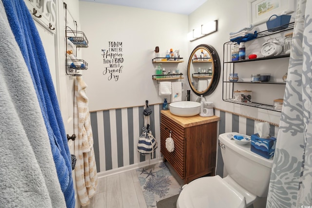 bathroom with toilet, vanity, and hardwood / wood-style flooring