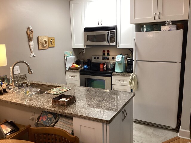 118 Salt Marsh Cir Unit 25B, Pawleys Island, SC 29585 - kitchen with stainless steel appliances, a sink, white cabinets, and stone counters