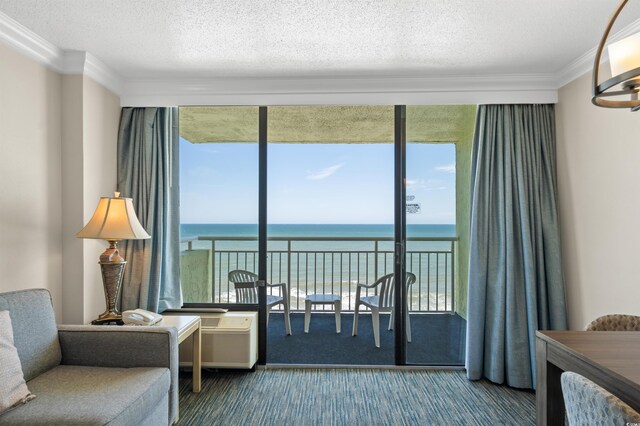 sitting room with carpet, a water view, a textured ceiling, and crown molding