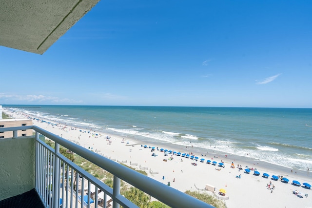 balcony with a water view and a view of the beach