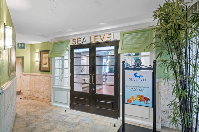 foyer featuring light tile patterned floors and french doors