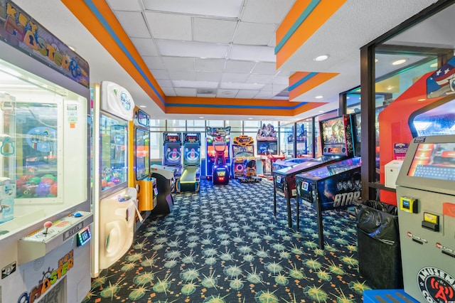 recreation room with a drop ceiling, a raised ceiling, and carpet flooring