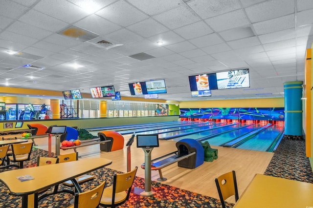 recreation room with bowling, visible vents, a paneled ceiling, and wood finished floors