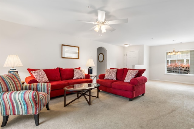 living room featuring ceiling fan with notable chandelier and light carpet