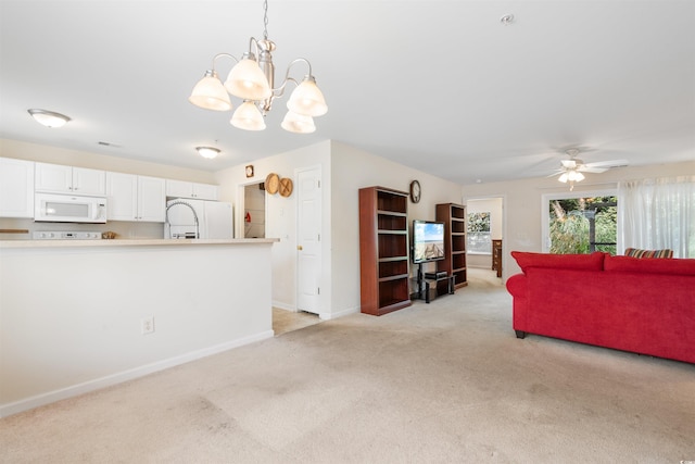 living room with ceiling fan with notable chandelier and light carpet