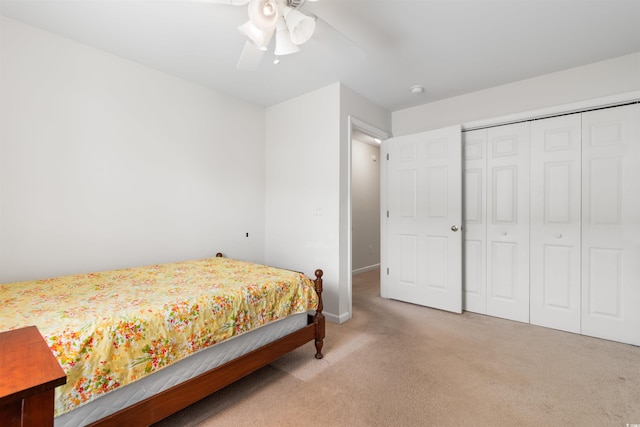 carpeted bedroom with ceiling fan and a closet