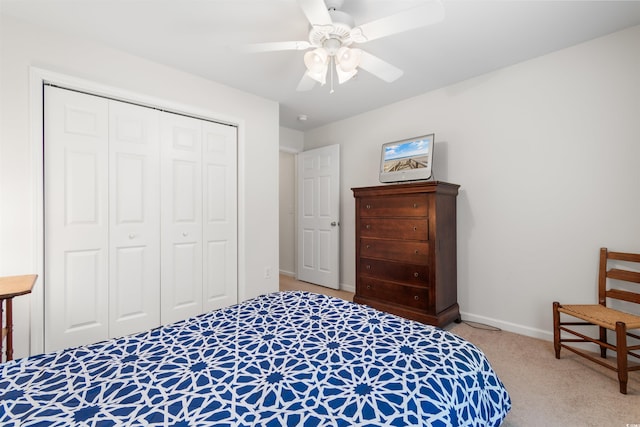 carpeted bedroom with ceiling fan and a closet