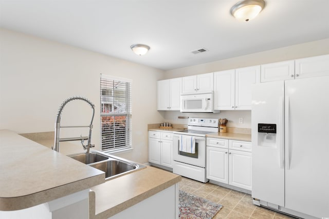 kitchen with white appliances, white cabinetry, and sink