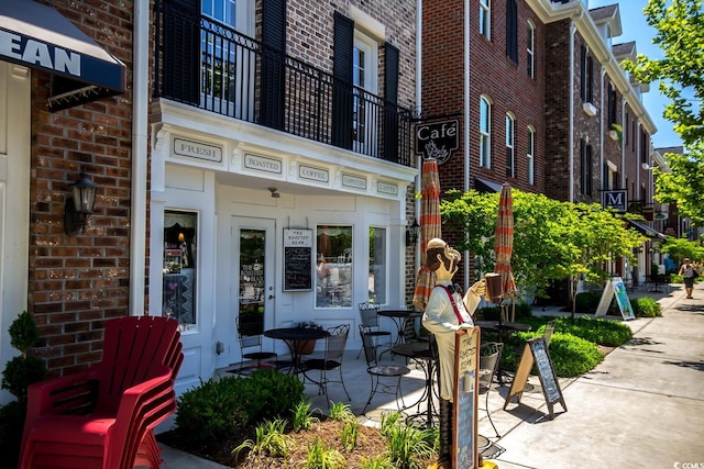 view of exterior entry with a balcony and a patio