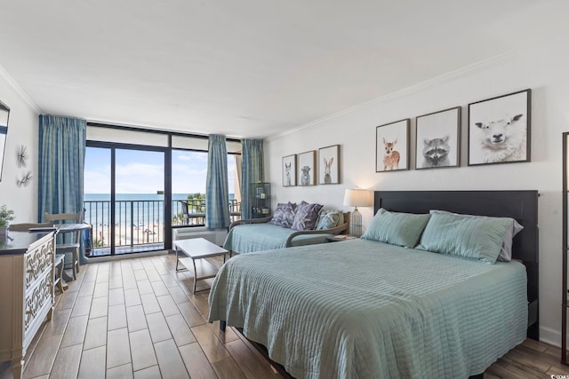 bedroom featuring floor to ceiling windows, a water view, ornamental molding, wood finished floors, and access to outside