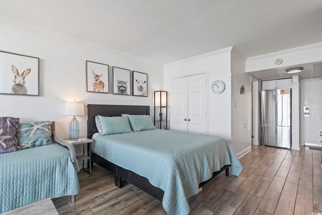 bedroom featuring baseboards, ornamental molding, a closet, and wood tiled floor