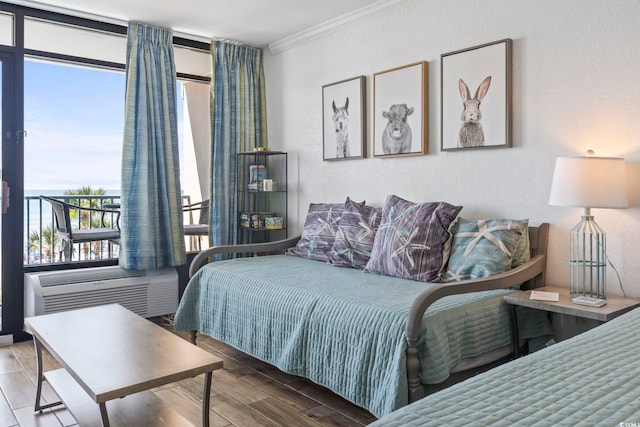 bedroom with a textured wall, crown molding, and wood finished floors