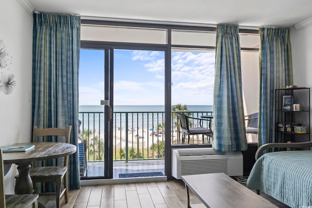 bedroom featuring wood finished floors, a water view, access to outside, floor to ceiling windows, and a wall mounted AC