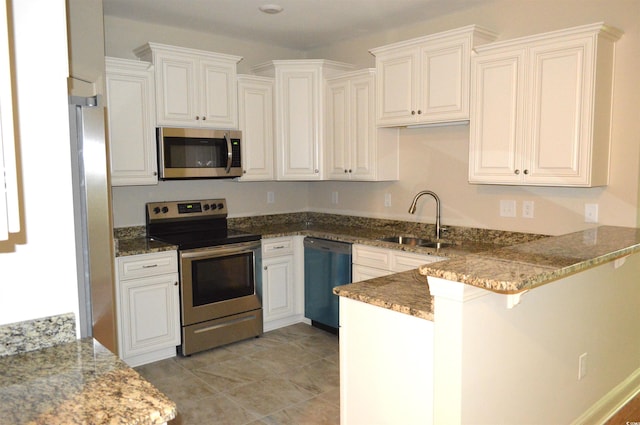 35 Delray Dr Unit 2-C, Murrells Inlet, SC 29576 - kitchen with appliances with stainless steel finishes, a sink, a peninsula, stone counters, and a breakfast bar area