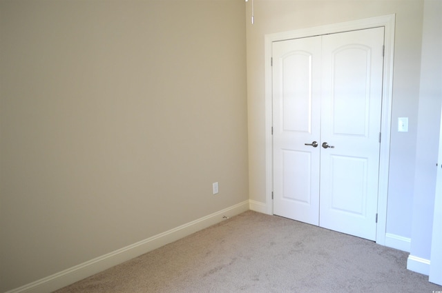 35 Delray Dr Unit 2-C, Murrells Inlet, SC 29576 - unfurnished bedroom featuring light carpet, a closet, and baseboards
