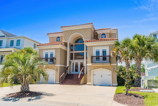 mediterranean / spanish house with a garage and french doors