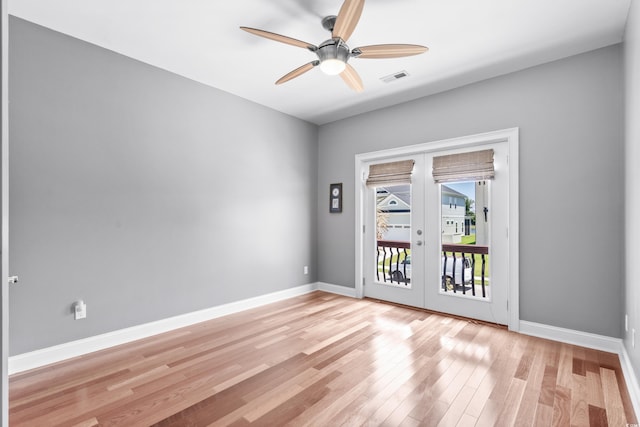 spare room with ceiling fan, light wood-type flooring, and french doors